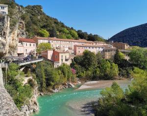 a bridge over a river with a town on a mountain at Bulles d'Olive Provence avec piscine - Jacuzzi en option in Nyons