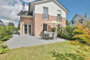 a patio with a table and chairs in front of a house at Haus Oberdeck 1 in Scharbeutz