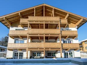 a large timber building with wooden balconies at Modern apartment near the ski area in Brixen im Thale