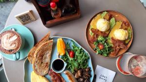 a table topped with plates of food and toast at Gardina Asoke Hotel & Residence in Bangkok