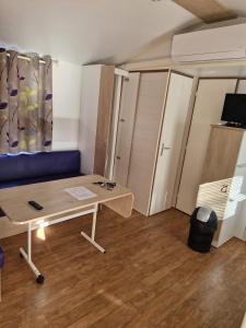 Cabrières-dʼAiguesにあるCamping Onlycamp Les Chênes Vertsのテーブルと青いソファが備わる小さなお部屋です。