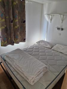 Cabrières-dʼAiguesにあるCamping Onlycamp Les Chênes Vertsのカーテン付きのベッドルームのベッド1台