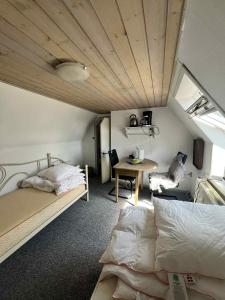 a bedroom with a bed and a desk and a table at Gravsgade 55 - Rolig gade i Hjertet af Ribe in Ribe