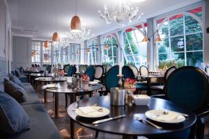 a restaurant with tables and chairs and windows at Seehotel Schwan in Gmunden