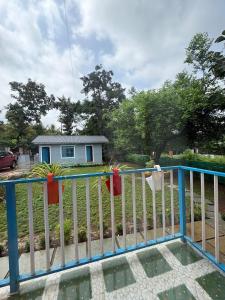 a white and blue fence in front of a house at Aweka Villa - 3 BHK Riverside - Karjat in Dhamni