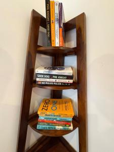 a wooden book shelf with a stack of books at Aweka Villa - 3 BHK Riverside - Karjat in Dhamni +37 photos