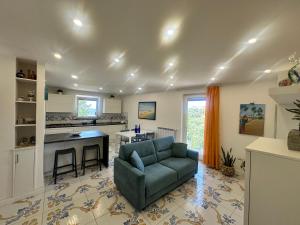 a living room with a couch and a kitchen at La Casa di Nonno Ciccio in Vico Equense