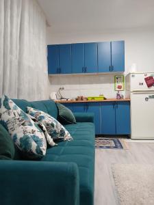 a blue couch in a kitchen with blue cabinets at Apartment Sunny in Sarajevo