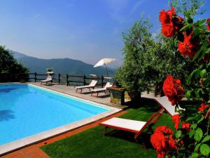 una piscina con sillas, mesa y sombrilla en Villa in Tuscany with Pool and Valley Views, en Castiglion Fiorentino