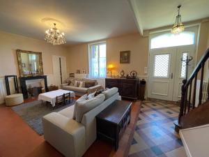 a living room with a couch and a table at La Villa Rouge in Saint-Martin-la-Rivière