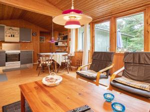 een keuken en woonkamer met een tafel en stoelen bij 6 person holiday home in Rødby in Rødby +14 foto's