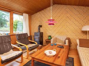 een woonkamer met een tafel en een houtkachel bij 6 person holiday home in Rødby in Rødby