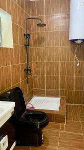 a bathroom with a black toilet and a shower at Chez Pauline in Sainte Marie