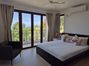 a bedroom with a bed and a large window at Belle Vue Lodge in Victoria