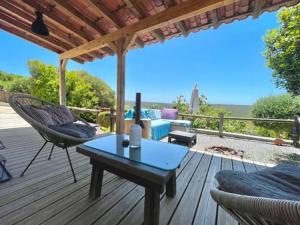 a deck with a couch and a table and chairs at CasaDaMeiaLuaArrifana in Aljezur