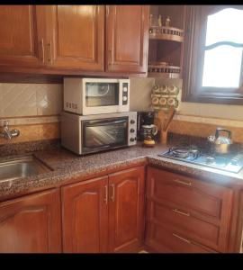 a kitchen with a microwave oven and a stove at étage 1 avec terrasse et vue sur mer in El Jadida +13 photos