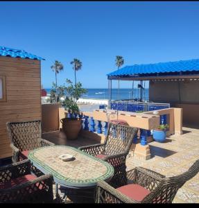 a patio with a table and chairs and the beach at étage 1 avec terrasse et vue sur mer in El Jadida