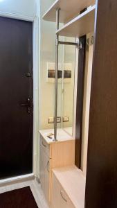 a bathroom with a sink and a mirror and a door at Однокомнатная Квартира в центре in Almaty
