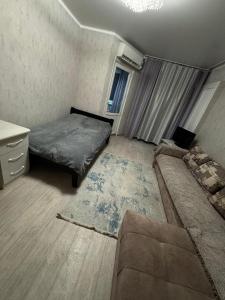 a small bedroom with a bed and a couch at Однокомнатная Квартира в центре in Almaty
