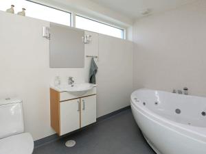ein Badezimmer mit Badewanne, Waschbecken und Toilette in der Unterkunft 6 person holiday home in Thyholm-By Traum in Thyholm + 34 Fotos