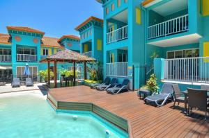 una villa con piscina e terrazza con sedie di Azzurra on Macrossan Adults only Apartment a Port Douglas