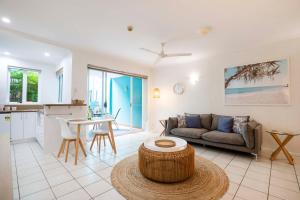 un soggiorno con un divano e un tavolo di Azzurra on Macrossan Adults only Apartment a Port Douglas