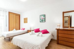 a bedroom with two beds with pink pillows at Blife Vitorya private apartment in Faro