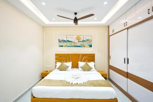 a bedroom with a bed and a ceiling fan at Shreshtam Apart Hotel, Gachibowli in Hyderabad