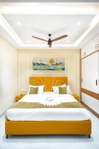 a bedroom with a large bed with a ceiling fan at Shreshtam Apart Hotel, Gachibowli in Hyderabad