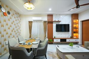 a dining room with a table and chairs and a television at Shreshtam Apart Hotel, Gachibowli in Hyderabad