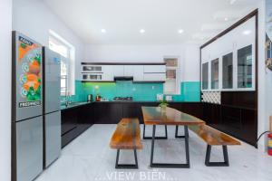 a kitchen with a wooden table and bench in it at Villages View Biển GREEN DAY 43 Trần Phú Thoáng Mát in Vung Tau