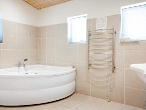 Un baño blanco con bañera y lavabo. en 6 person holiday home in Thyholm, en Thyholm
