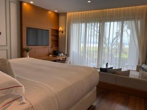 a bedroom with a large bed and a large window at The Fortress Resort & Spa in Ahangama