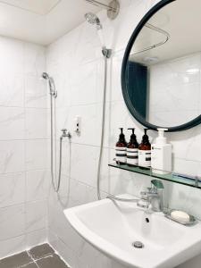 a bathroom with a shower and a sink and a mirror at Luna stay in Seoul