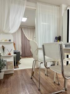 a living room with white chairs and a table at 루나스테이 in Seoul