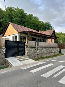 a house with a gate and a stone wall at Casa Nuvio in Poiana Aiudului