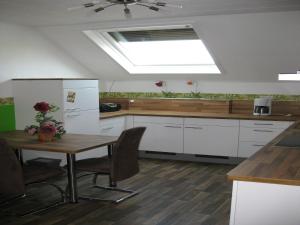 a kitchen with a table with chairs and a skylight at Kyll Valley Forest Apartment in Kyllburg +20 photos