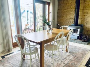 a dining room table with chairs and a fireplace at Updated Cottage on Large Sunny Block - 5 mins-CBD in Canadian