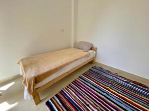 a bed in a room with a colorful rug at Beautiful view for Relaxation AC WiFi -Couples Allowed- in Madinaty