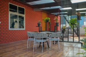 a restaurant with tables and chairs and a brick wall at Shreshtam Apart Hotel, Gachibowli in Hyderabad