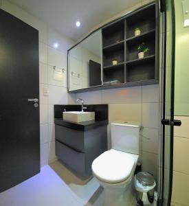 a bathroom with a toilet and a sink and a mirror at One Way by Hosppedar in Tambaú