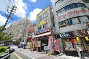 a street in an asian city with tall buildings at Mensore Houese in Naha
