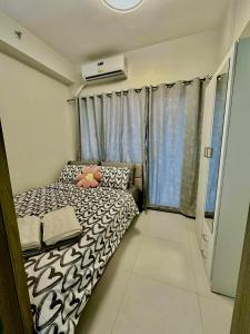 a small bedroom with a bed and a window at Fame Residences in Sampong