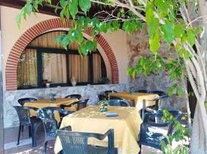 a restaurant with tables and chairs and a tree at BeB Verdemare in Santa Teresa di Riva