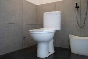 a white toilet in a bathroom with a shower at Kuleum Camp And Cabin By ARBA in Baruhtunggul +43 photos