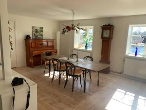a dining room with a table and chairs and a clock at Sjösidan in Jädraås +6 photos