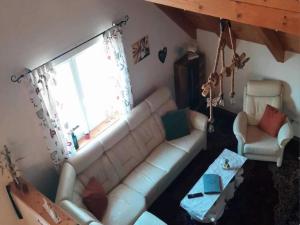 a living room with a white couch and a window at Wohnung in Neuhaus nahe Skigebiet Petzen in Neuhaus +22 photos