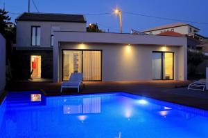 a swimming pool in front of a house at Ferienhaus in Estreito Da Calheta mit Privatem Pool und Meerblick in Jardim do Mar