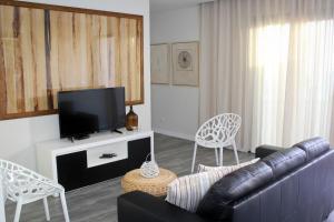 a living room with a couch and a flat screen tv at Ferienhaus in Estreito Da Calheta mit Privatem Pool und Meerblick in Jardim do Mar +14 photos
