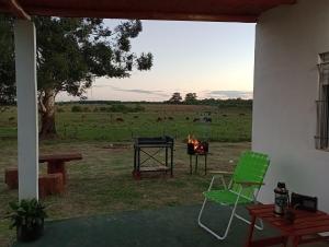 a patio with a fire grill and a green chair at Lo Pituco casa de campo in Federación +7 photos